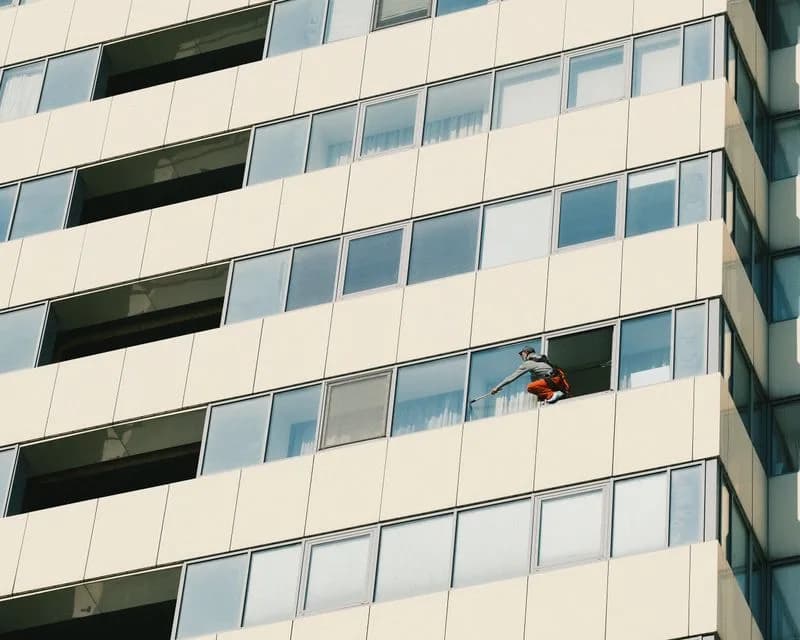Window cleaner washing glass on a building facade