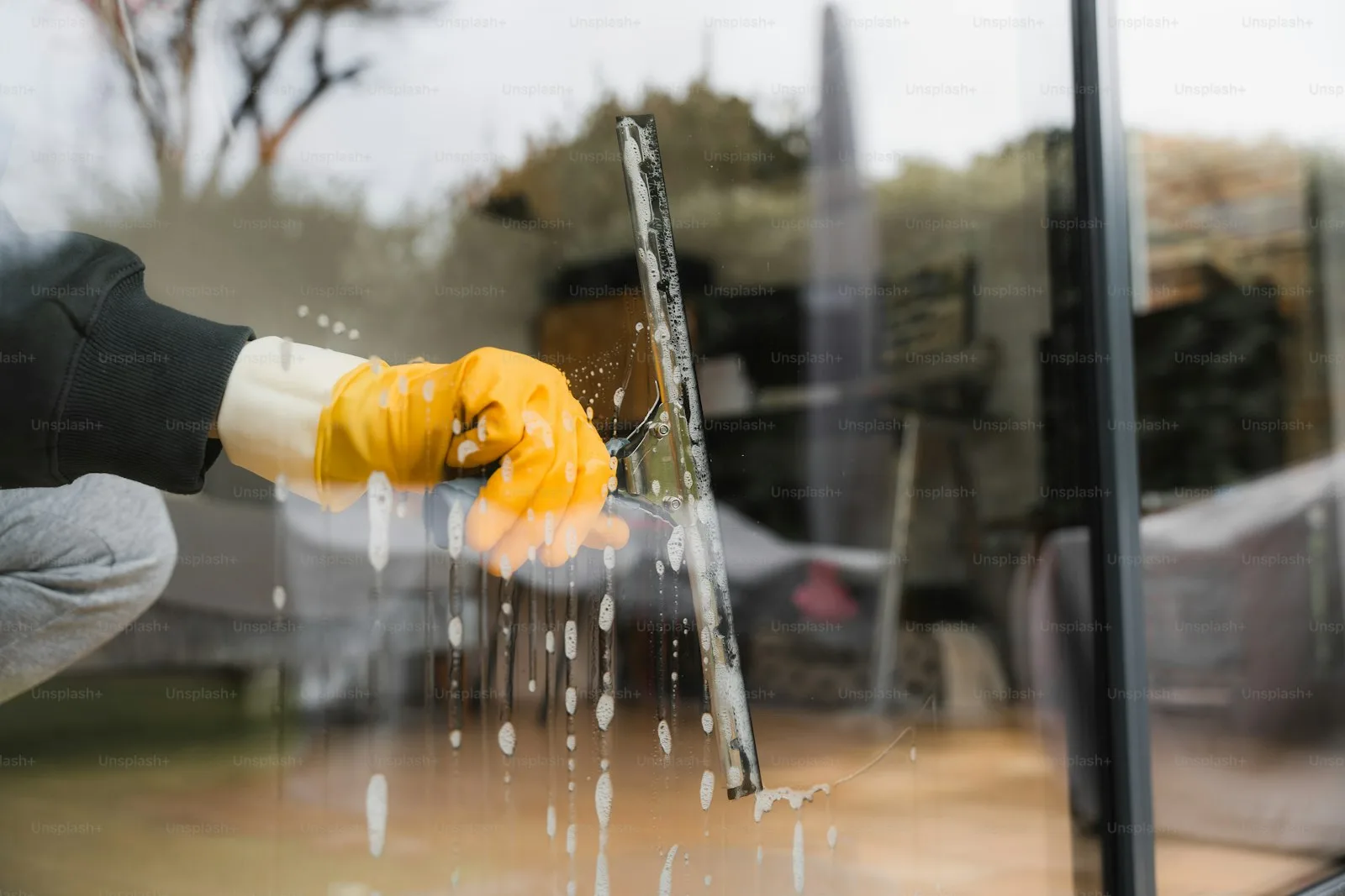 Window cleaner washing glass on a building facade